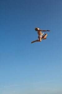 man in black shorts jumping under blue sky during daytime